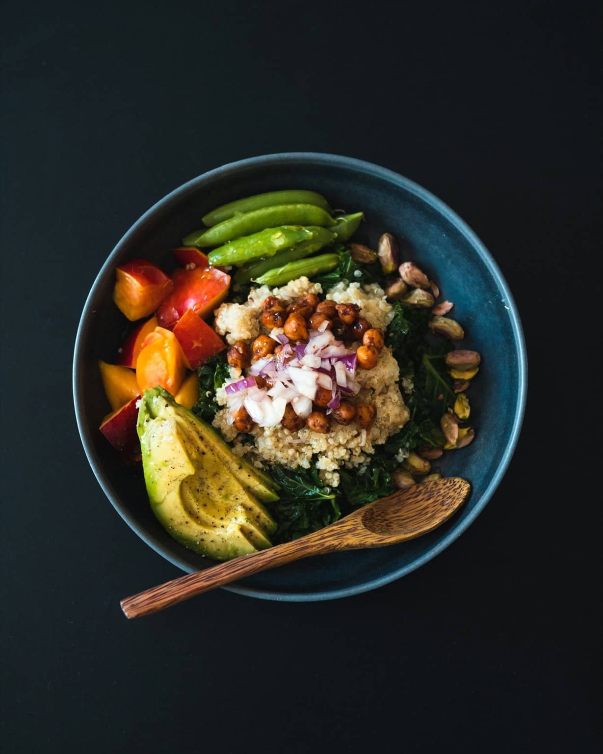 Buddha bowl végétarien dans un bol bleu avec cuillère en bois