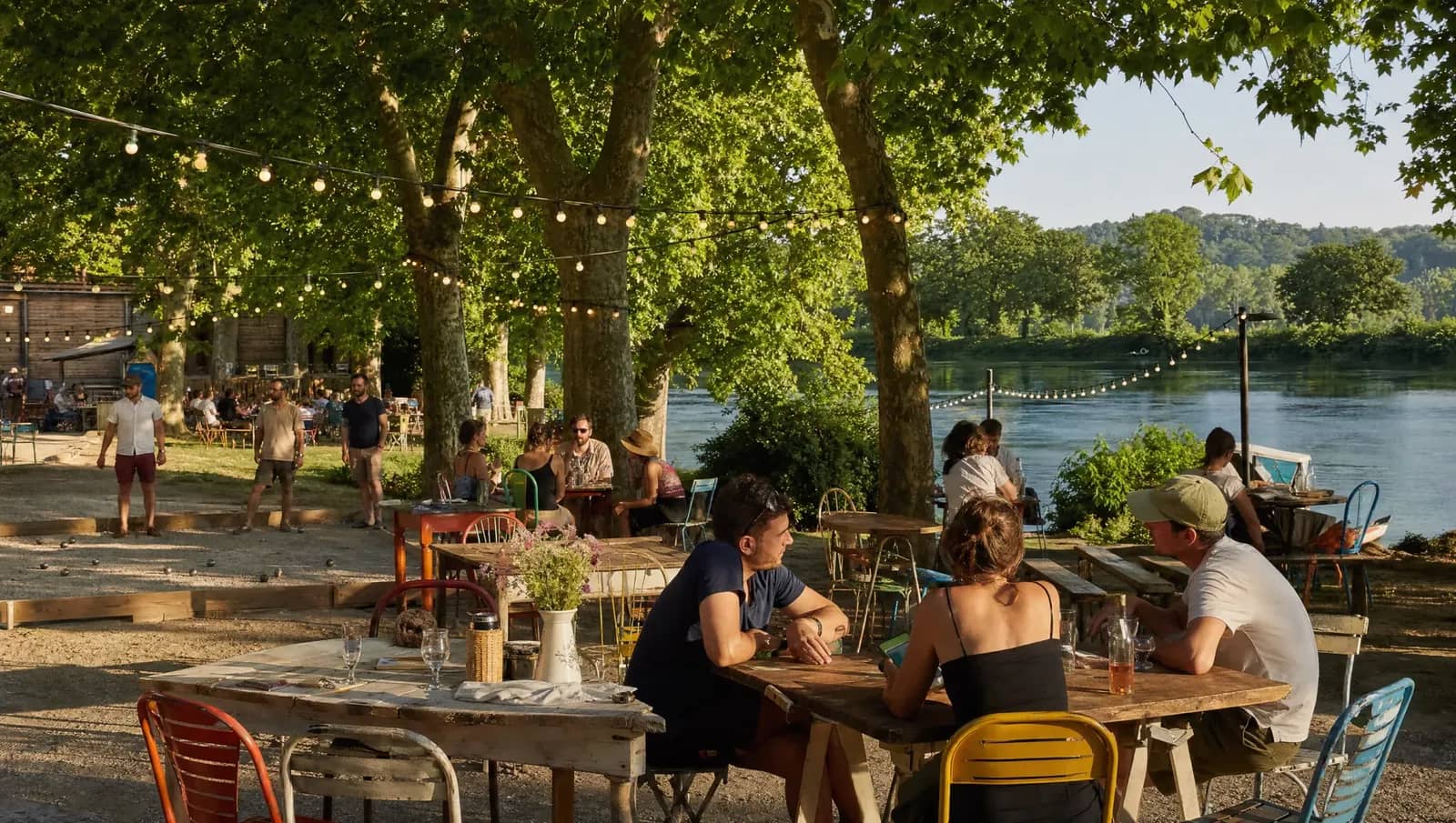 Guinguette au bord de la Saône près de Lyon, guirlandes lumineuses et terrasse sous les platanes