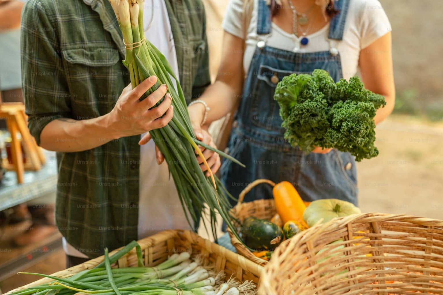 Couple de producteurs maraîchers devant un panier de légumes frais