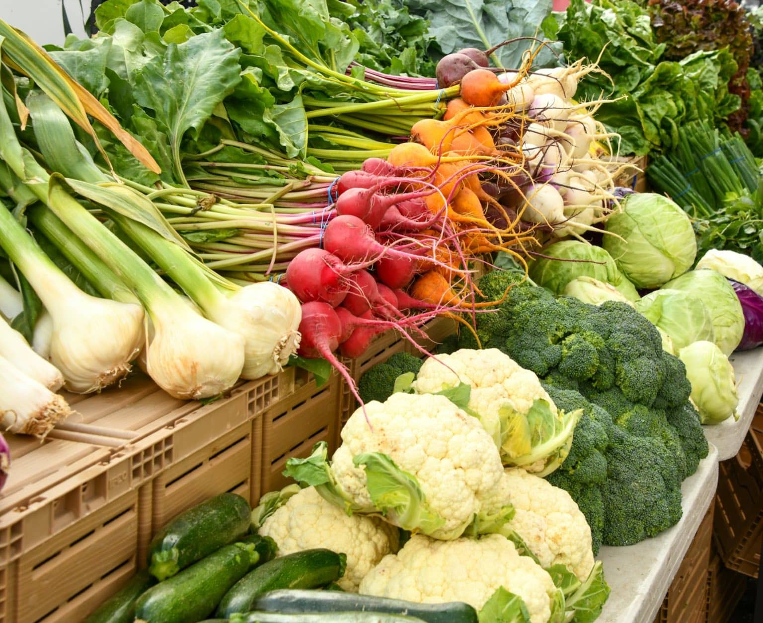 Légumes verts et rouges de saison sur une table en bois rustique