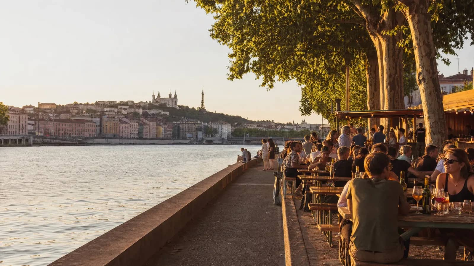 Terrasse au bord de la Saône à Lyon à l'heure dorée, avec la colline de Fourvière en fond