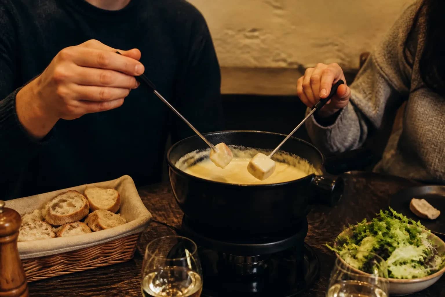 Deux personnes partageant une fondue savoyarde dans un restaurant lyonnais