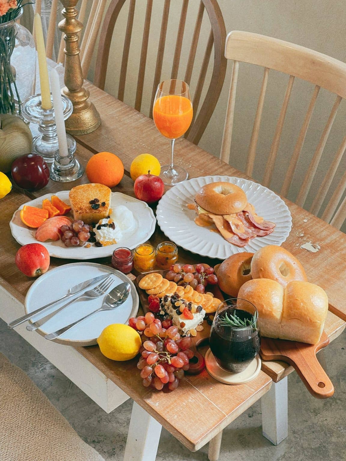 Table de brunch dressée avec viennoiseries, fruits frais et café