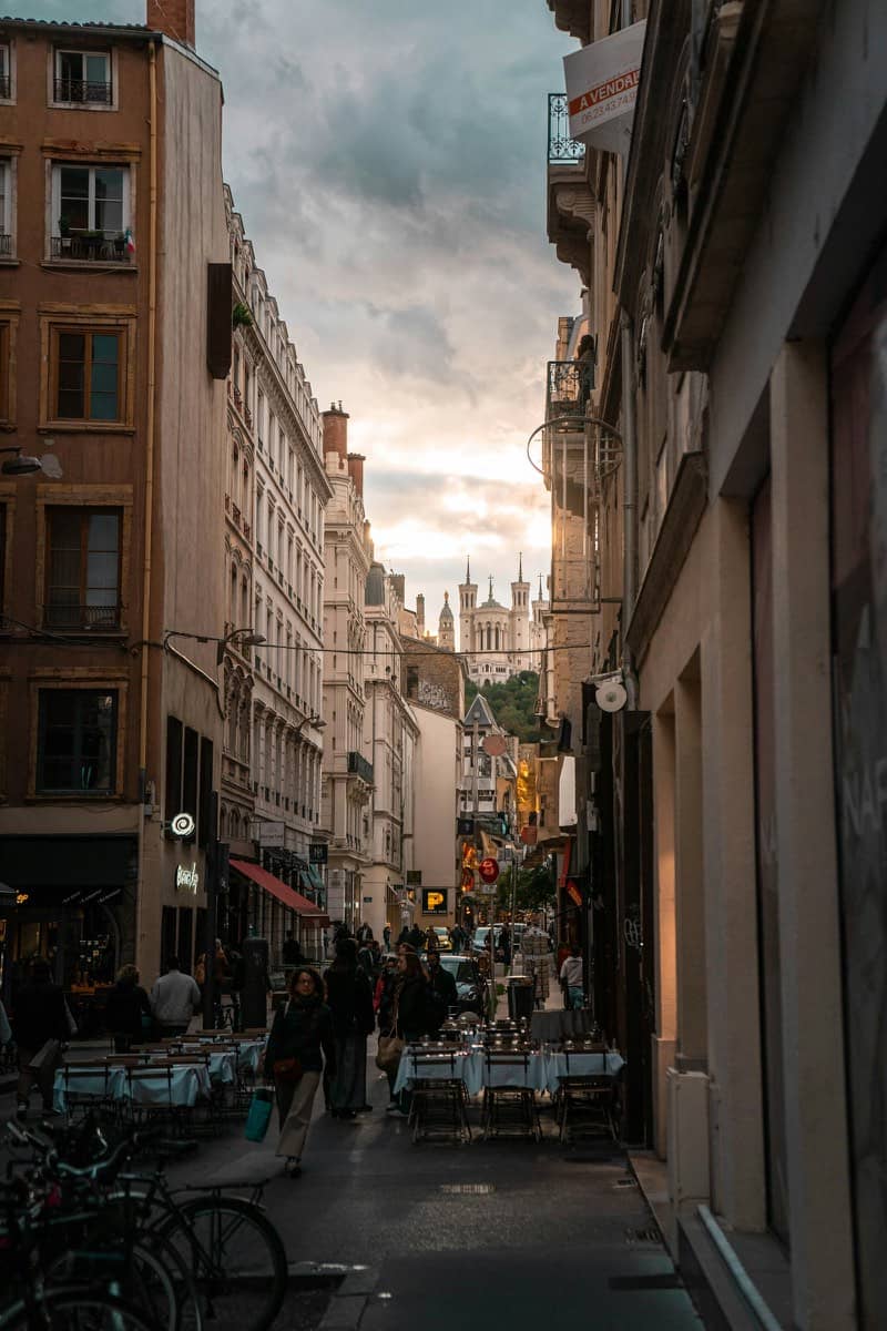 Rue étroite et pavée du Vieux-Lyon bordée de hauts immeubles historiques en pierre