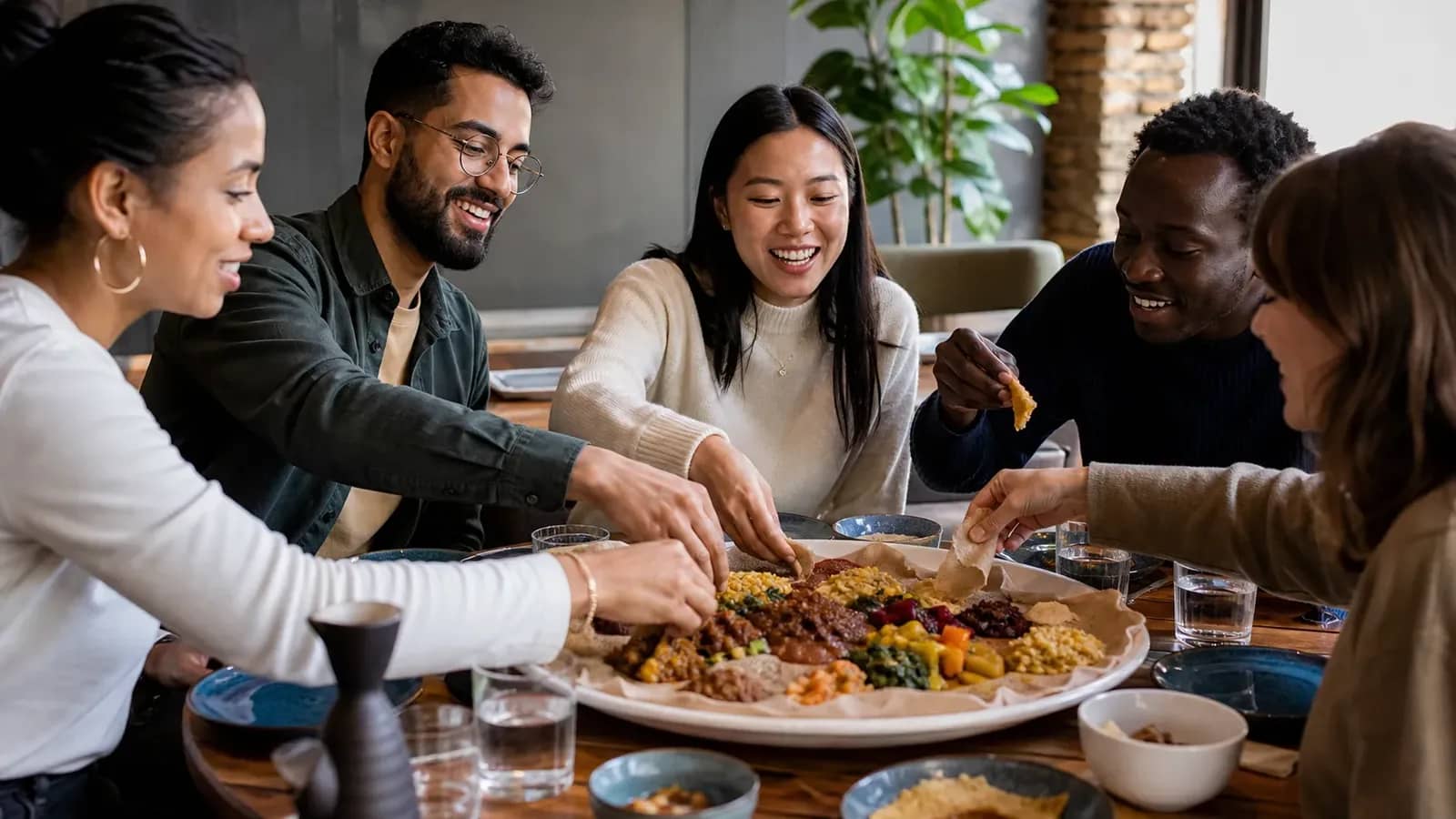 Repas éthiopien partagé autour d’une grande injera dans un restaurant lyonnais