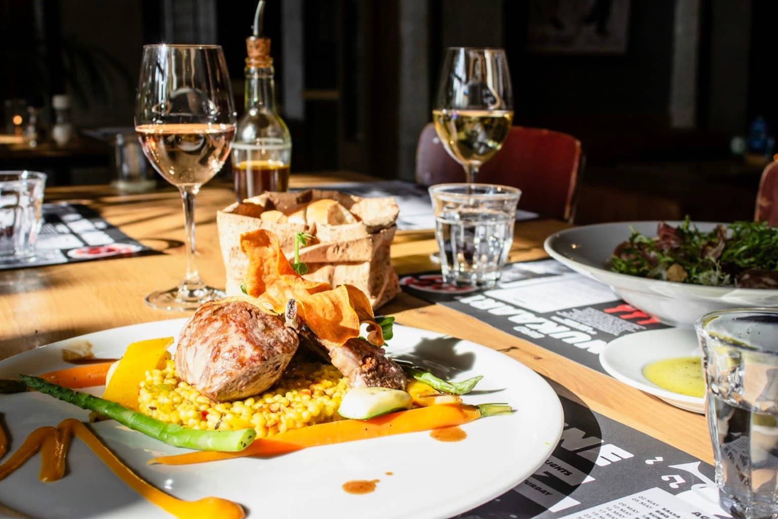 Table de restaurant éclairée le soir, plats et verres en gros plan