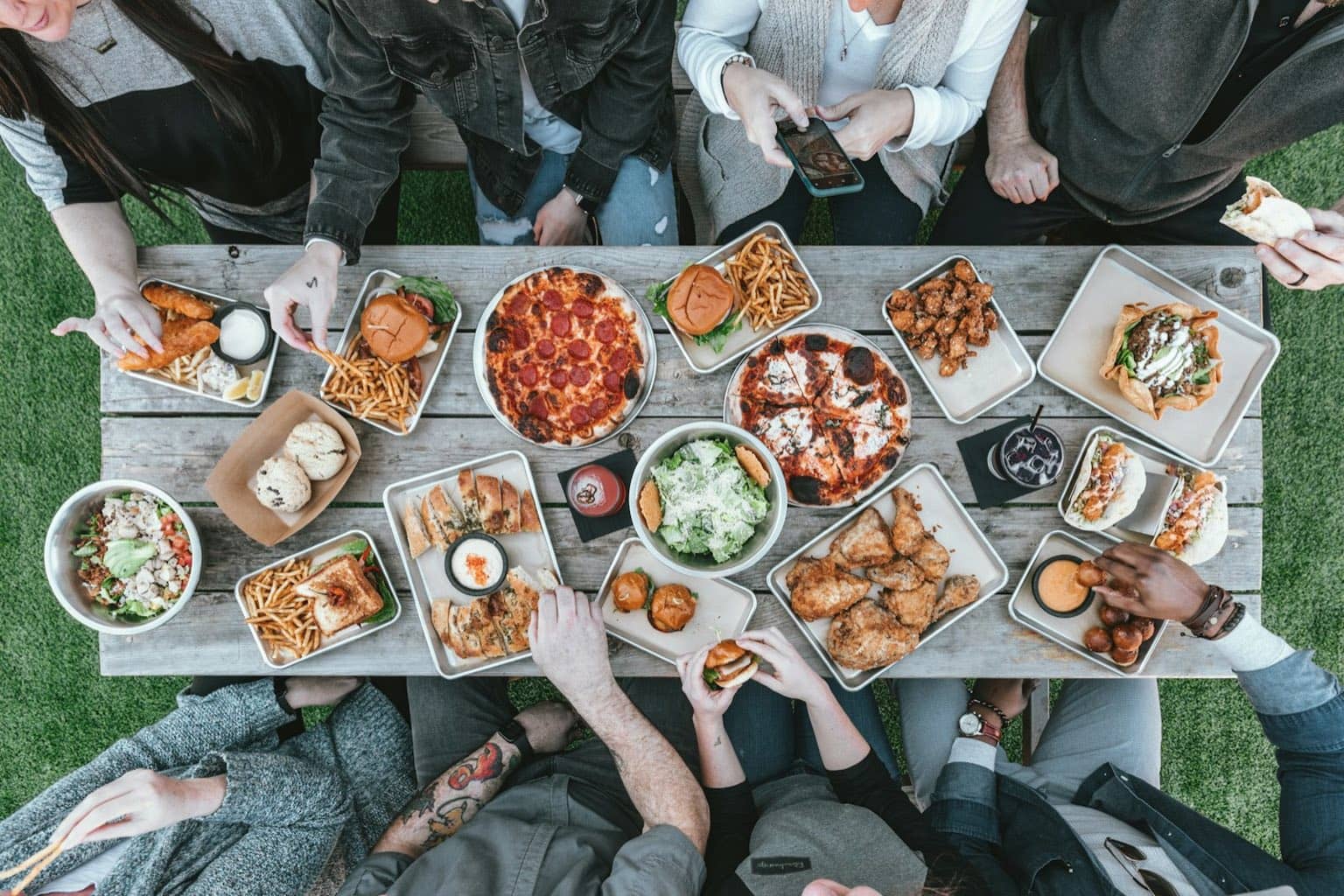 Groupe d'amis partageant un repas autour d'une table conviviale