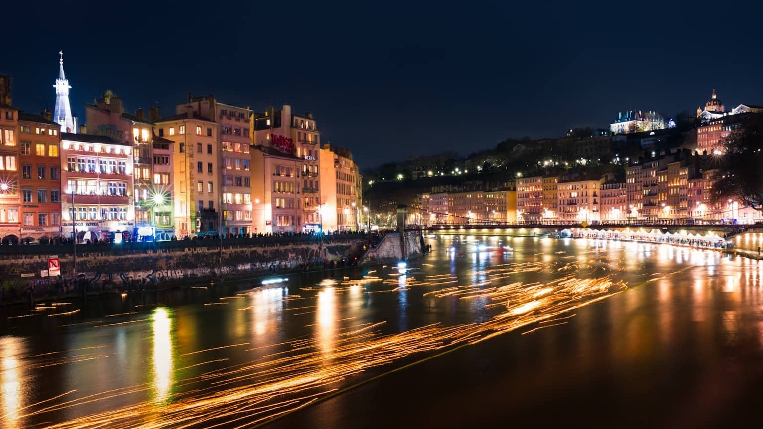 Façades historiques de Lyon illuminées le soir, avec terrasses et restaurants animés du centre-ville
